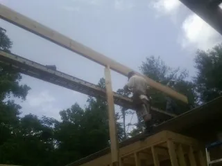Carpenter setting a ridge beam over a new addition frame — Ice Dam Removal by Roofing Brothers in Dayton