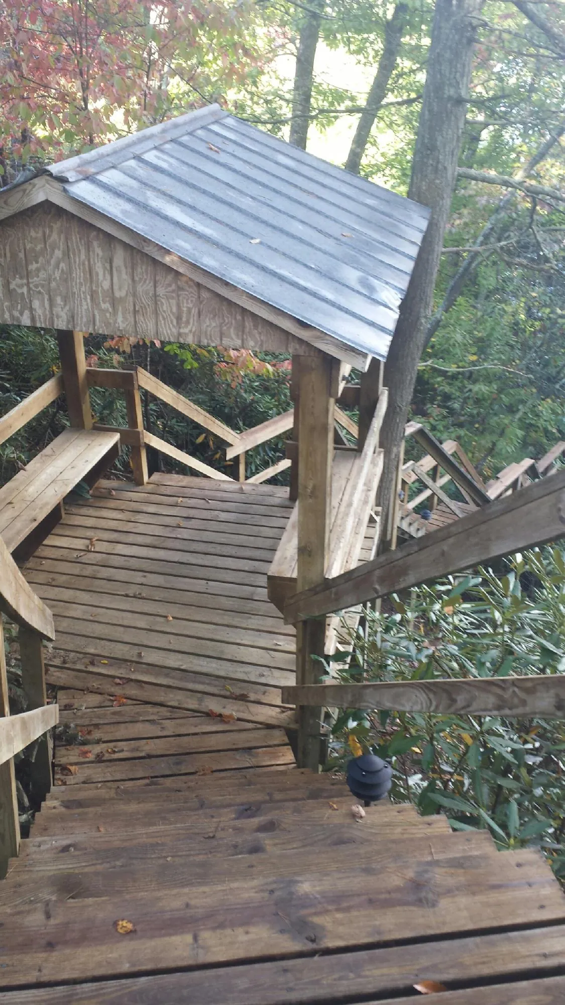 Metal roofed shelter over wooden steps on a wooded walkway — Skylight Repair & Installation work by our crew in Dayton